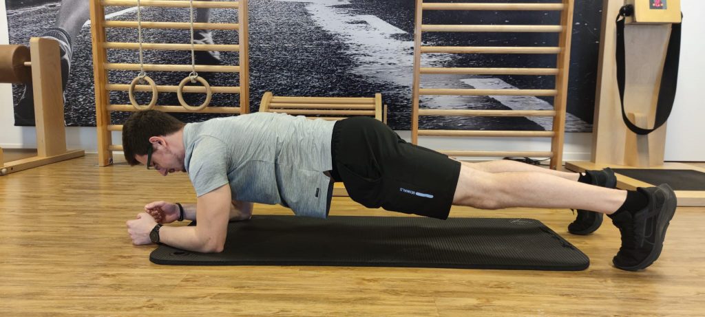 Physiotherapeut zeigt Übung für einen Starken Rücken.